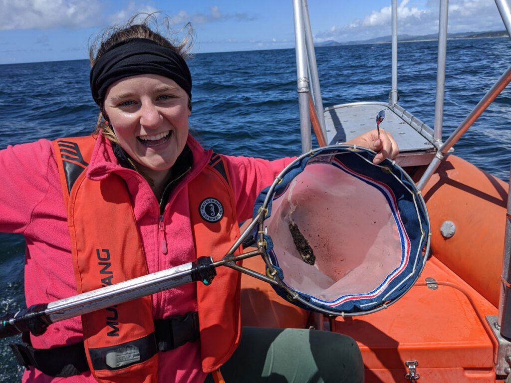 a researched holding a specimen of whale poop